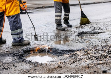 pothole repair - maintenance service workers working on the road