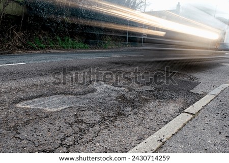 Potholes, loose gravel where the surface has collapsed, and cracking; junction of London Road (B1204) and Upper Horsebridge Road, Hailsham, East Sussex, UK.