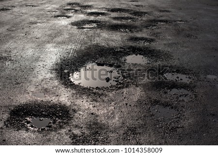 potholes in the road looking like alien craters