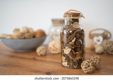 The potpourri in glass bottle on a wood table, provides a relaxing scent and celebration. Wellness concept and self-care background.