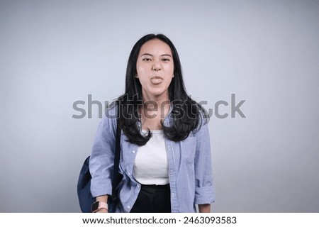 Potrait Of Funny Young Asian Woman Student Sticking Tongue Out Showing Silly Face Isolated On White Background