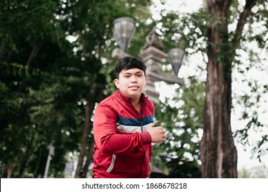 Potrait Happy Asian Young Man Jogging In A Park With Jacket 