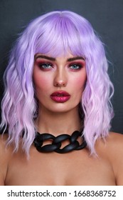 Potrait of young beautiful tanned woman with lilac hair and bright fancy makeup