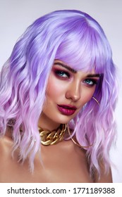 Potrait of young beautiful tanned woman with lilac hair and bright fancy makeup