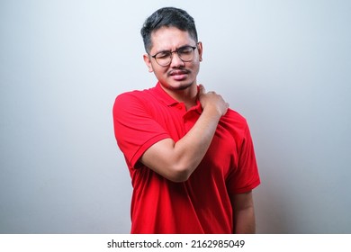 Potrait Of Young Handsome Asian Man Wearing Casual Shirt Suffering Backache Standing Over White Background