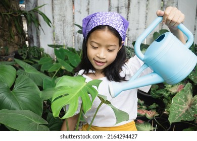 Potriat Of Adorable Little Asian Girl Planting Plants On The Garden.