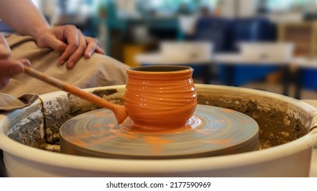 Potter coloring ceramic pot on a Potter's wheel at workshop. Hobbies, craft and handwork. Teaching pottery on a potter's wheel. Healthy free time. Selective focus - Powered by Shutterstock