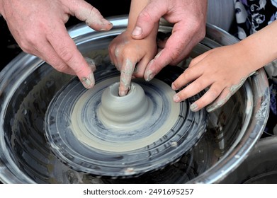 Potter helps to the child at a pottery master class. - Powered by Shutterstock