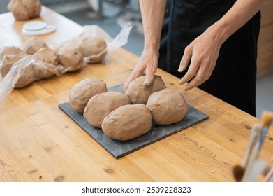 A potter kneads clay before using it in the workshop. Close-up of a man's hands.  - Powered by Shutterstock