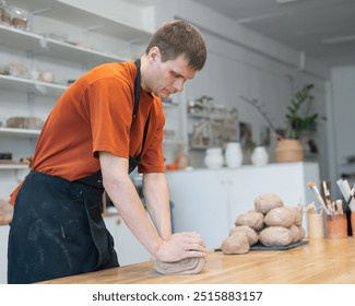 Potter kneads clay before using it in the workshop.  - Powered by Shutterstock