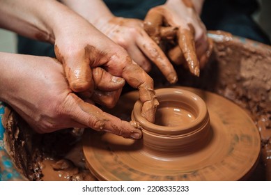 Potter Teach Pupil On Circle Wheel In Workshop. Hands Close Up