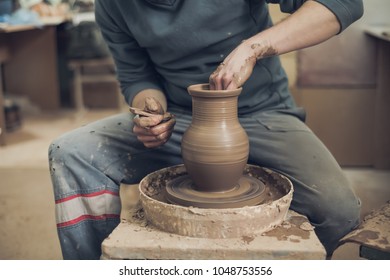 Potters hands close up making creating ceramic jar vase pot on pottery wheel macro front view. Potter at work hands in raw fireclay craft factory authentic. The ability to create beauty.