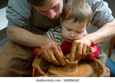 A Potters Hands Guiding Pupil Hands To Help Him To Work With The Ceramic Wheel