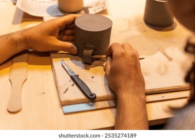 A potter's hands shaping a clay vessel on a pottery wheel, Ceramic workshop top view - Powered by Shutterstock