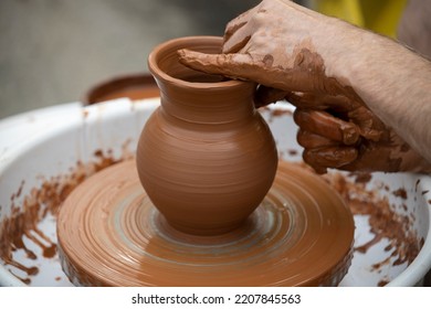 Potter's hands working clay on a potter's wheel. Master making clay pottery. - Powered by Shutterstock