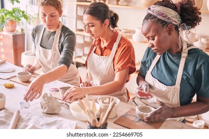 Pottery class, ceramic workshop or group design sculpture mold, clay manufacturing or art product. Diversity people, retail sales store or startup small business owner, artist or studio women molding - Powered by Shutterstock