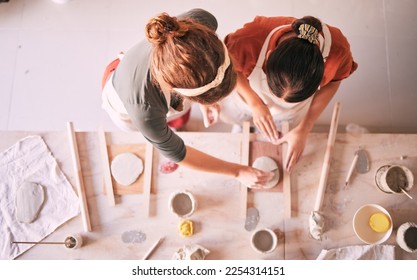 Pottery class, ceramic workshop and team design sculpture mold, clay manufacturing or art product. Diversity, retail store and top view of startup small business owner, artist or studio women molding - Powered by Shutterstock