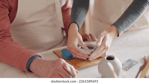 Pottery class, workshop and art learning of a teacher and student working with clay. Creative, elderly teaching and studio artist student work with hands to make a ceramic mug design for fun - Powered by Shutterstock