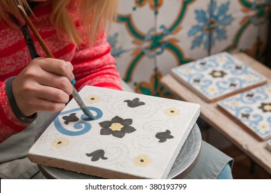 A Pottery Decorator Painting A Ceramic Tile With Floral Motifs In His Work Table In Caltagirone, Sicily