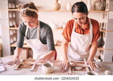 Pottery, design and small business people in workshop teamwork, collaboration and startup production. Clay, manufacturing and creative woman, artist or partner working together on sculpture process - Powered by Shutterstock