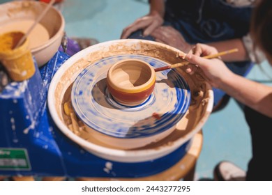 Pottery lesson master class for kids children, process of making clay pot on pottery wheel, potter hands creating ceramic crockery handcrafts, ceramist molding and painting jar or vase - Powered by Shutterstock