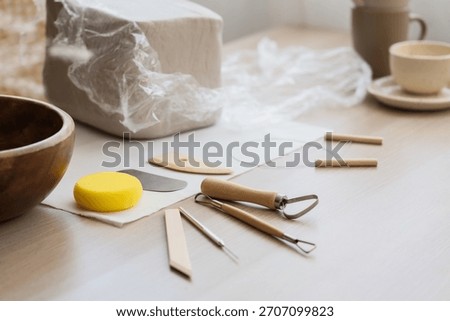 Pottery loop, needle, ribs and sponge on table in home studio, closeup