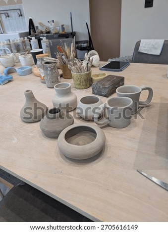 Pottery on a table in a pottery studio that's been thrown on the wheel 