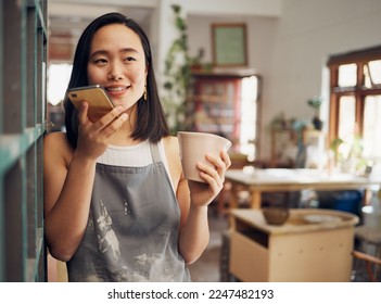 Pottery, phone call and coffee with an asian woman recording a vote note or message in her workshop. Communication, drink and talking with a female designer or artisan in her studio to design - Powered by Shutterstock