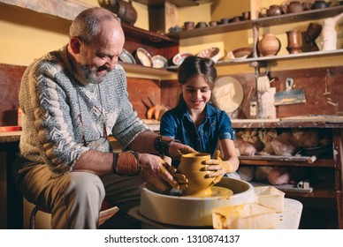 Pottery workshop. Grandpa teaches granddaughter pottery. Clay modeling. - Powered by Shutterstock