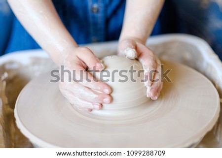 Similar – Young female sitting by table and making clay or ceramic mug