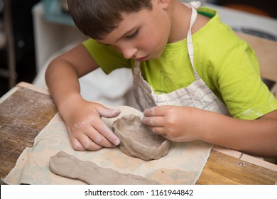 Pottery workshop for kids, raw clay, sculpting tools, glazing and painting clay pots - Shutterstock ID 1161944842