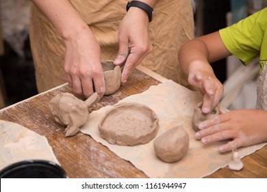 Pottery workshop for kids, raw clay, sculpting tools, glazing and painting clay pots - Powered by Shutterstock