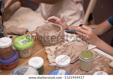 Pottery workshop for kids, raw clay, sculpting tools, glazing and painting clay pots