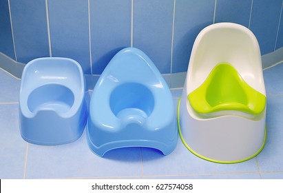 Potty training. Three kinds of pottys on the floor in bathroom.  Which potty our toddler choose to pee?