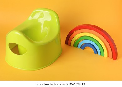 Potty And Wooden Rainbow On Orange Background