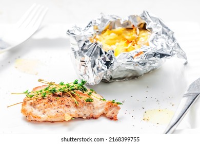 Poulry Steak With Baked Potato In Aluminum Foil