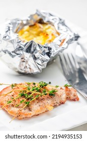 Poulry Steak With Baked Potato In Aluminum Foil