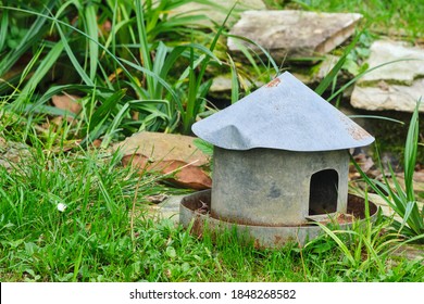 Poultry Feeder As An Ornament In A Garden