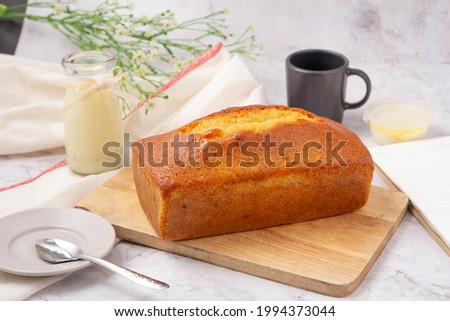 Pound cake with lemon glaze on cutting board, milk in glass bottle. Stock photo © 