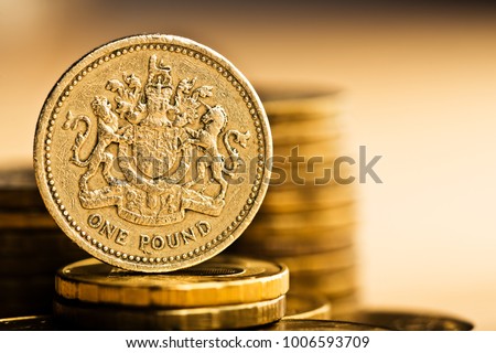 pound GBP coin and gold money on the desk
