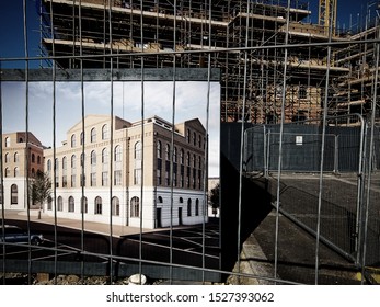 POUNDBURY, DORCHESTER, UK - October 21 2018: Building Site Perimeter Hoarding Showing Artists Impression Of Building Under Construction.