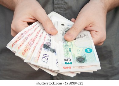Pounds banknotes held by a man's hands