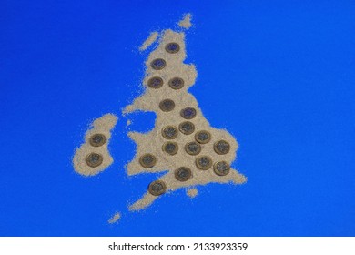Pounds Coins On A Map Of The United Kingdom Made From Sand. The Cost Of Living In The UK Concept.