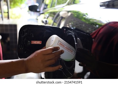 Pour additive liquid into car tank. Maintenance for long use without repair. Additional fluid for diesel. - Shutterstock ID 2154741591
