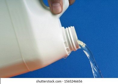 Pour bleach in closeup on blue background - Shutterstock ID 1565246656