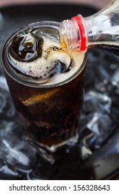 Pour Cola Into A Glass With Ice.