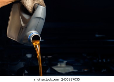 Pour engine oil from the lubricant bottle. Engine background, oil change shop engine service industry - Powered by Shutterstock