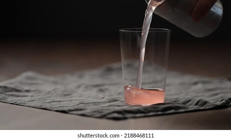 Pour Guava Drink From Can Into Tumbler Glass On Table, Wide Photo