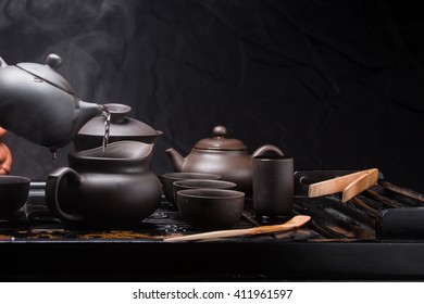 
Pour hot water with a small Chinese teapot. Incredible Asian tea brewing ritual. China, tea, tableware, kettle, tradition, health, tea ceremony, vigor, energy, Asia,