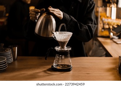 Pour over filter coffee alternative brewing method. Pouring hot water over roasted and ground coffee beans contained in paper filter - Shutterstock ID 2273942459